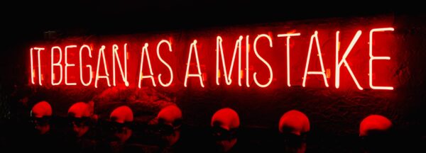 Neon sign which says 'It began as a mistake'